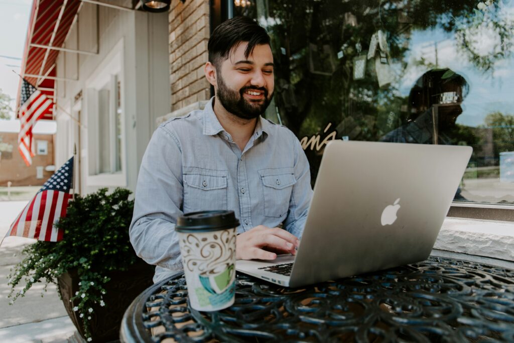 Person working on computer outside of coffee shop